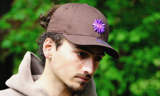 Man showcasing Bellflower embroidered cap outdoors